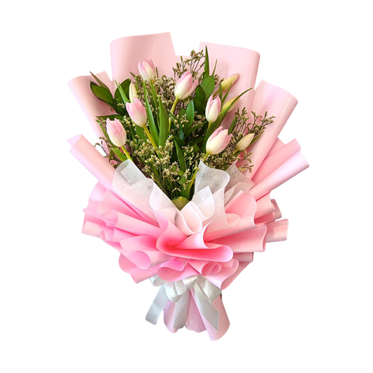 Bouquet of pink single tulips and limoniums, with lush green contrast  of ruscus leaves, elegantly wrapped in pink floral paper and white ribbon detail.