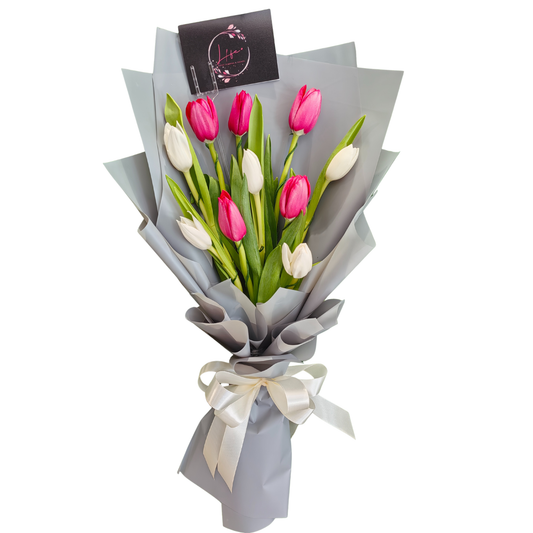 Candy Delight tulip bouquet in buds - 5 soft pink and 5 white tulips wrapped in elegant floral paper, hand-tied with white satin ribbon, accompanied by a complementary message card.