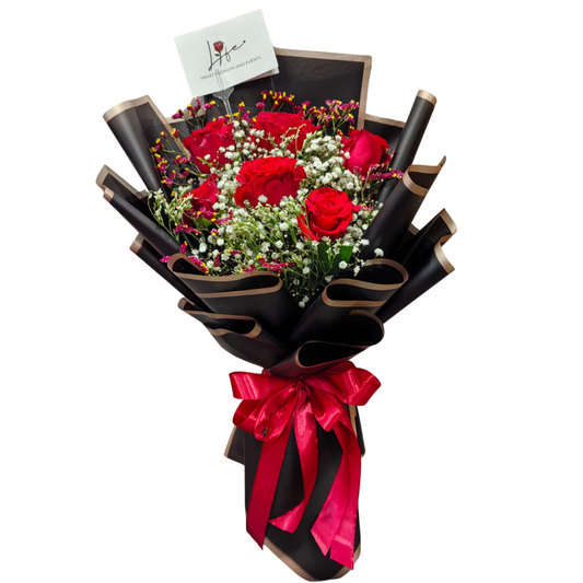 Bouquet of 6 red roses with white gypsophila and mixed color limoniums, wrapped in fancy black floral paper with gold trimmings, and lovely red ribbon detail.