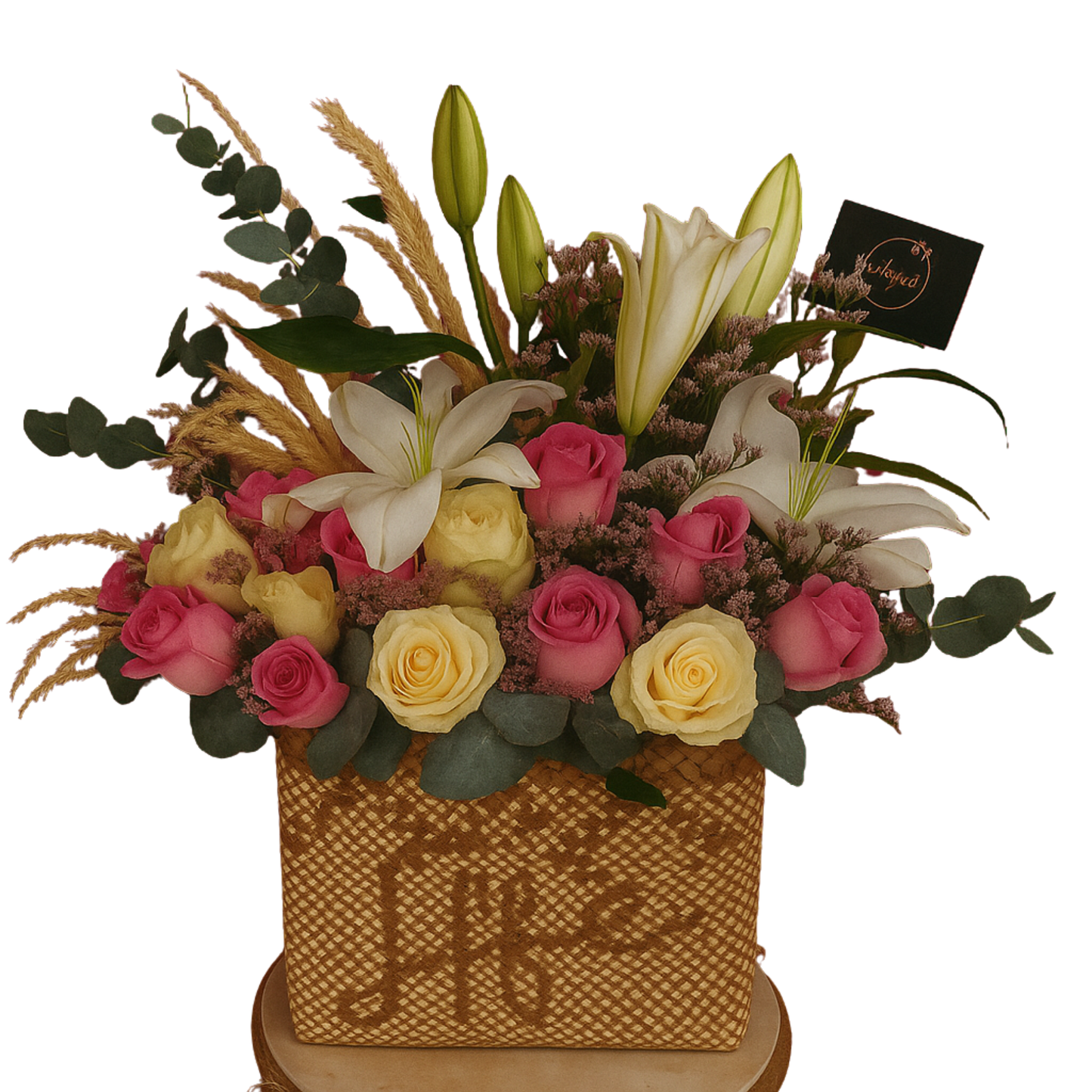 Ethereal Blush floral arrangement with pink and white roses, lilies, limoniums, eucalyptus, and pampas grass in a handwoven buri bag. Solid white background