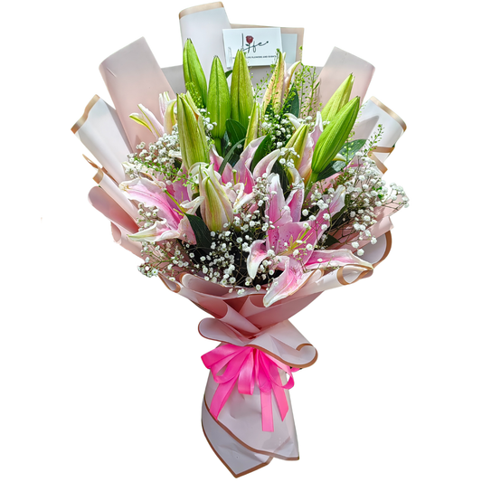 Fresh bouquet of pink stargazer lilies and white gypsophila wrapped in blush pink and gold cellophane with bright pink ribbon-– floral gift by Hayat Flowers Dubai.