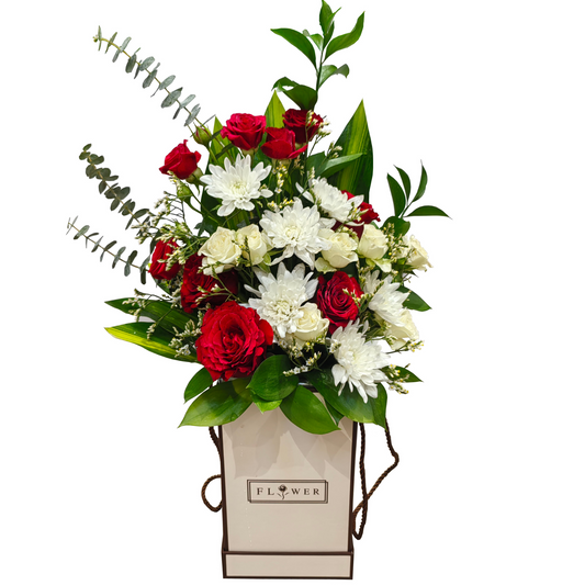An elegant display of red spray roses and white chrysanthemums, with lisianthus and limoniums as fillers, added with lush foliage mix of single ruscus, eucalyptus Baby Blue, and Jamica leaves arranged in a decorative flower box.