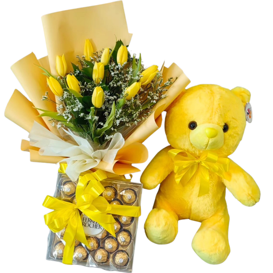 Sunny Embrace Love Bundle with 10 yellow tulips and white limonium bouquet, soft yellow teddy bear, and a box of Ferrero Rocher chocolates tied with yellow ribbon by Hayat Flowers and Events