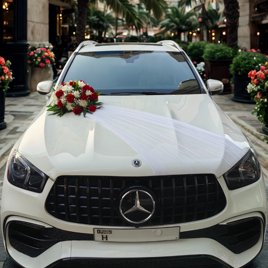 White Mercedes-Benz SUV wedding car decorated with custom floral arrangement and a white lace draping.