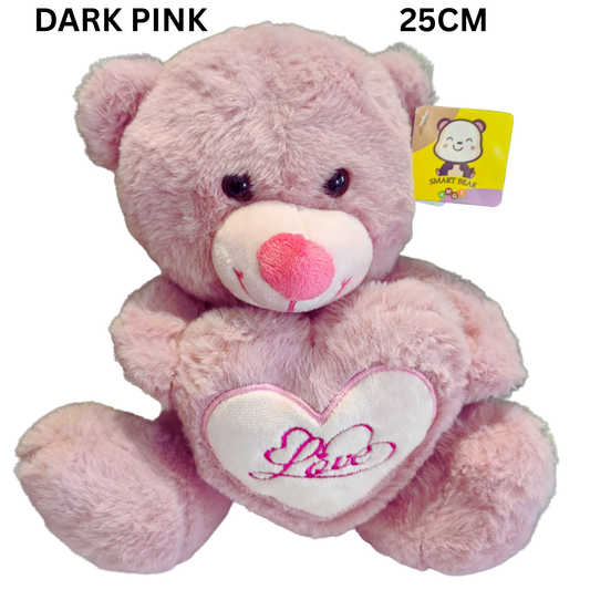 Pink teddy bear with a heart pillow that says 'Love'